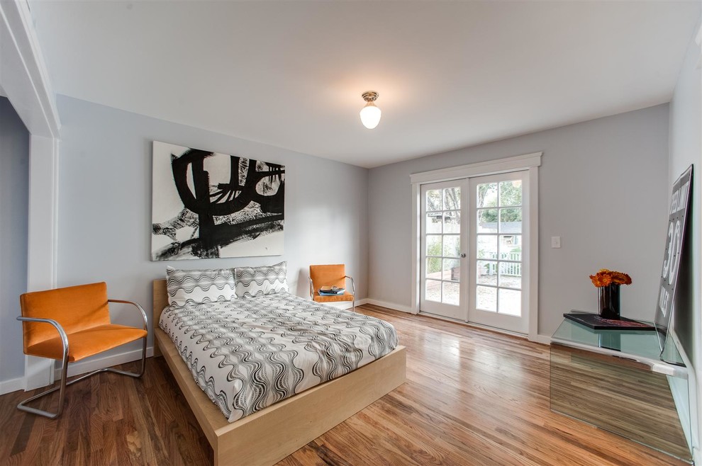 Esempio di una camera degli ospiti stile americano di medie dimensioni con pareti grigie e pavimento in legno massello medio