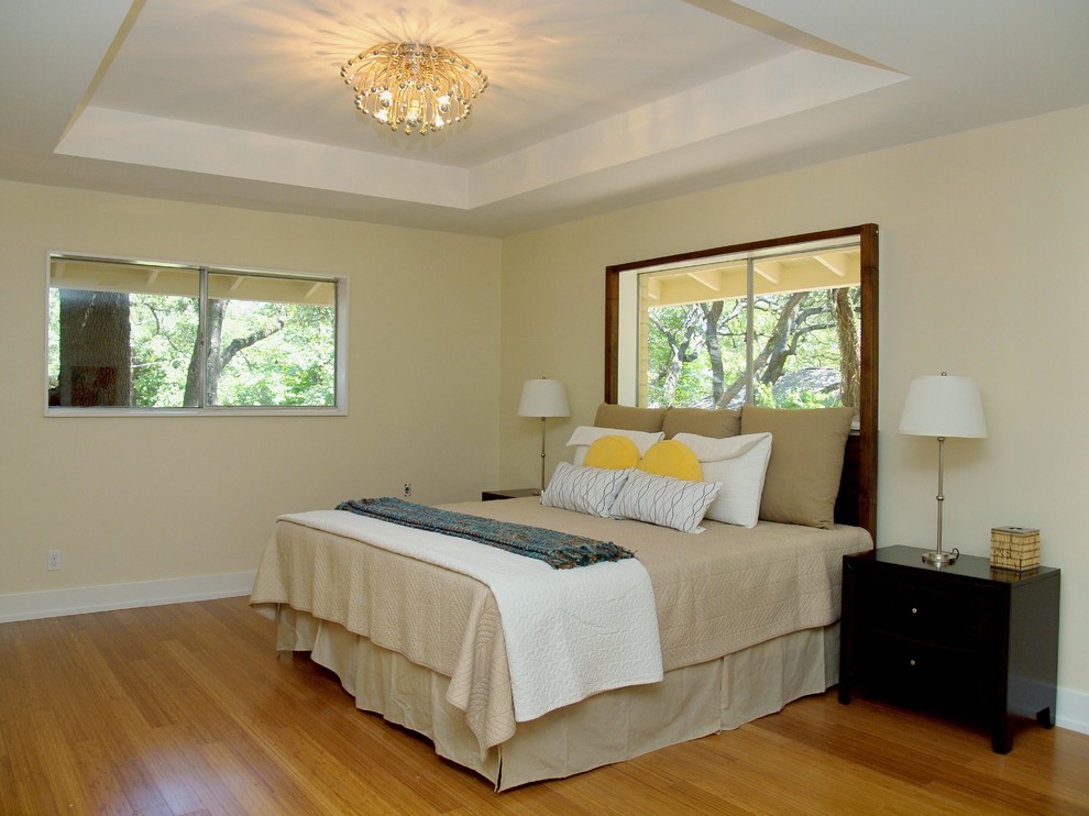 Immagine di una camera da letto eclettica di medie dimensioni con pareti gialle e pavimento in bambù
