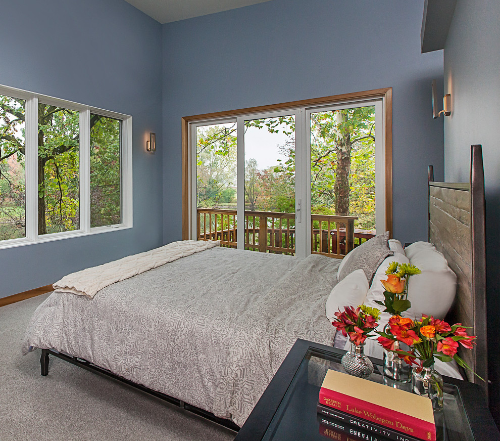На фото: хозяйская спальня среднего размера в современном стиле с синими стенами, ковровым покрытием, стандартным камином, фасадом камина из штукатурки и серым полом