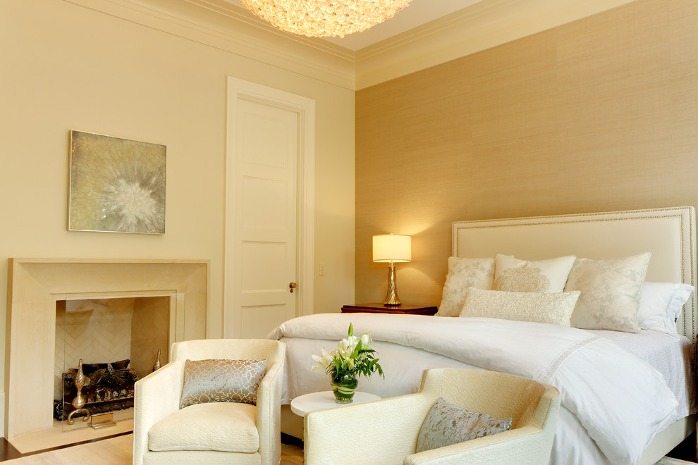 Ejemplo de dormitorio principal clásico renovado de tamaño medio con paredes beige, suelo de madera en tonos medios, todas las chimeneas y marco de chimenea de piedra