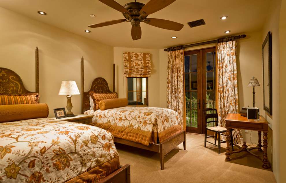 フェニックスにある巨大なサンタフェスタイルのおしゃれな客用寝室 (ベージュの壁、カーペット敷き、コーナー設置型暖炉) のインテリア