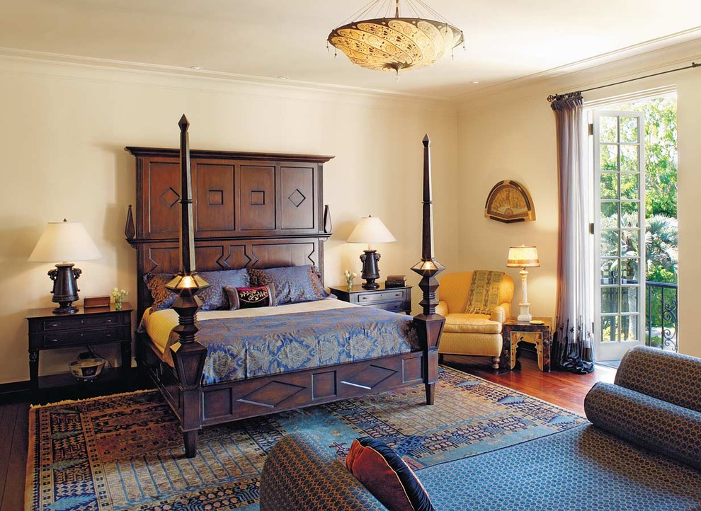Modelo de dormitorio mediterráneo sin chimenea con paredes beige y suelo de madera en tonos medios