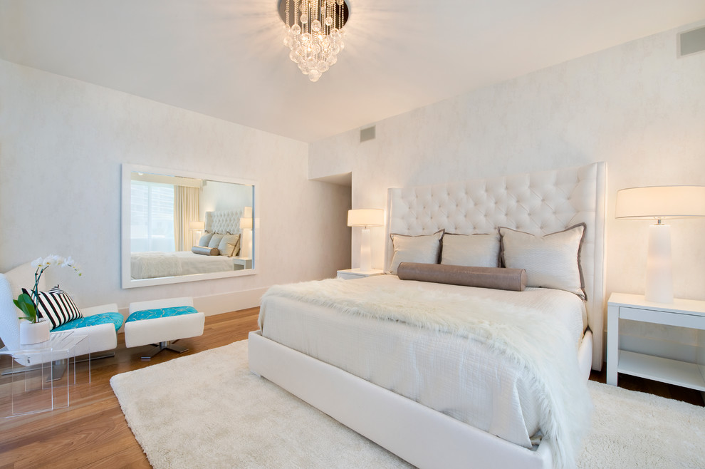 Modelo de dormitorio actual sin chimenea con paredes blancas y suelo de madera en tonos medios
