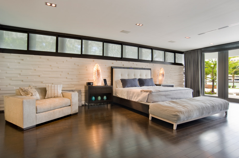 Immagine di una camera da letto design con pareti bianche e parquet scuro