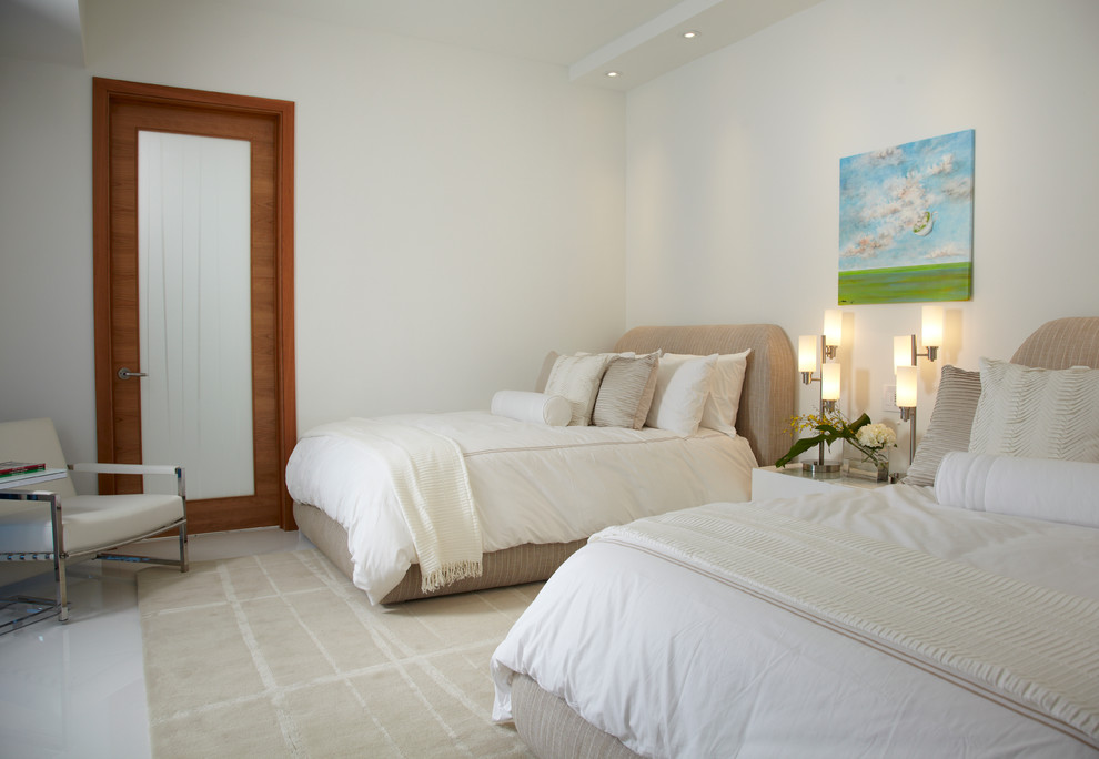 This is an example of a large contemporary guest bedroom in Miami with white walls and marble flooring.