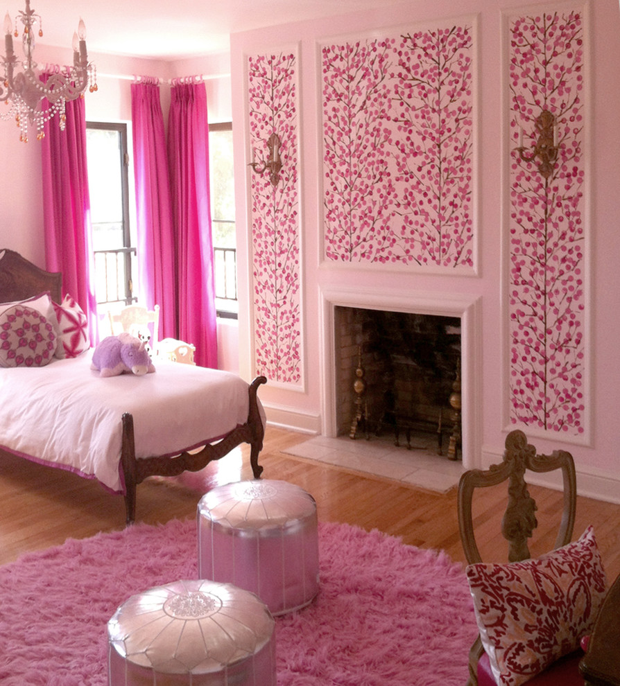 Réalisation d'une chambre tradition avec un mur rose, parquet foncé, une cheminée standard et un manteau de cheminée en plâtre.