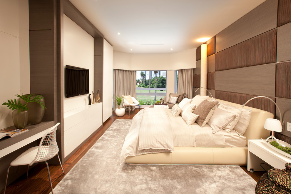 Transitional medium tone wood floor bedroom photo in Miami with beige walls
