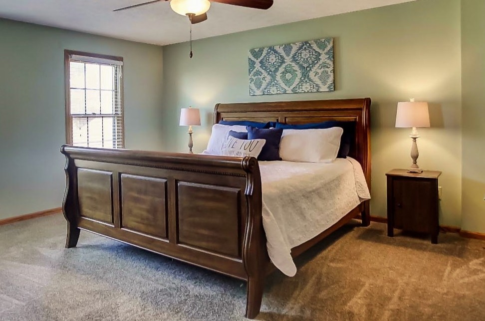 Imagen de dormitorio principal tradicional renovado de tamaño medio sin chimenea con paredes verdes, moqueta y suelo beige
