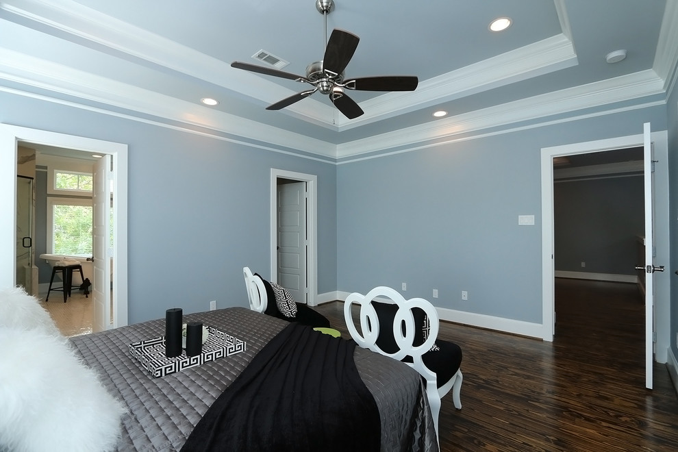 Modelo de dormitorio principal de estilo americano de tamaño medio sin chimenea con paredes azules y suelo de madera oscura