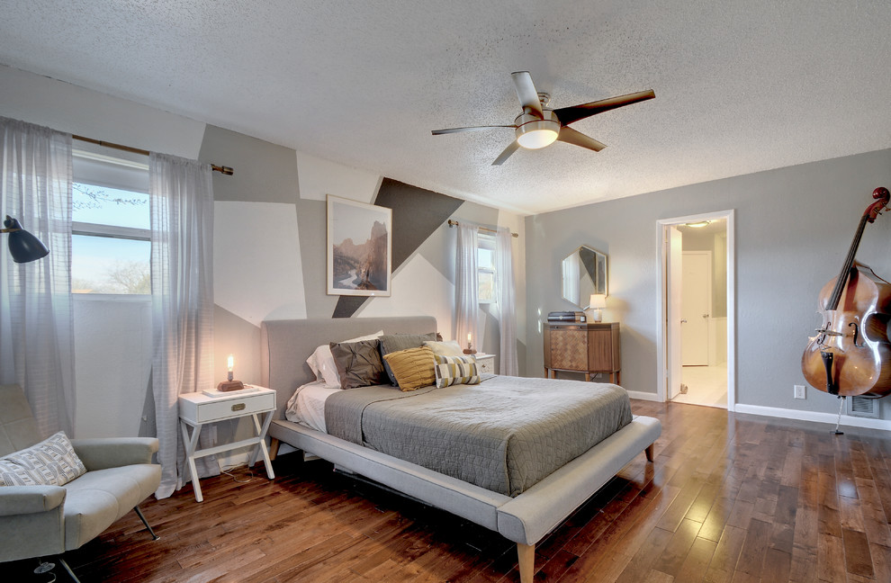 Trendy dark wood floor and brown floor bedroom photo in Austin with gray walls