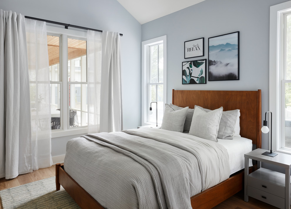 Idee per una camera da letto stile marino con pareti blu, pavimento in legno massello medio e pavimento marrone