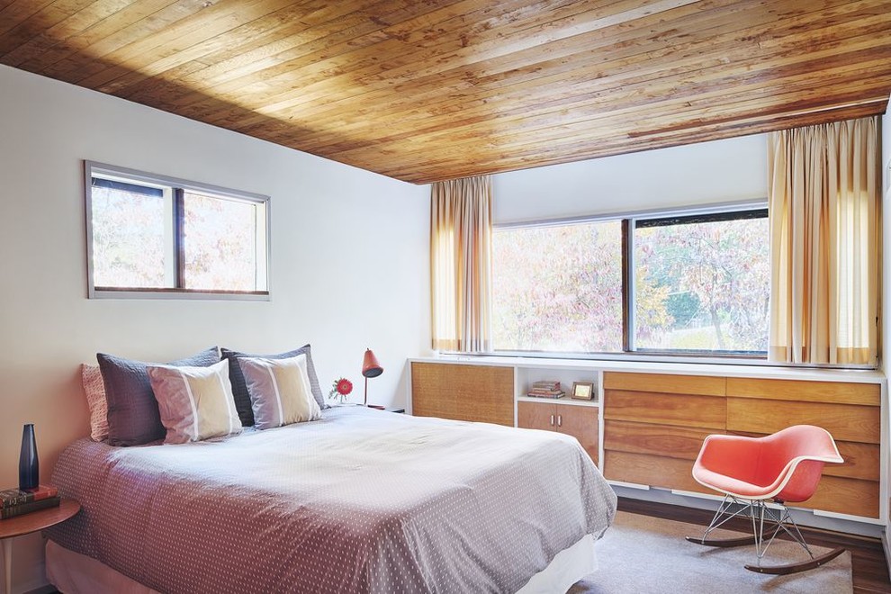 ニューヨークにある小さなミッドセンチュリースタイルのおしゃれな主寝室 (白い壁、ラミネートの床、茶色い床) のインテリア