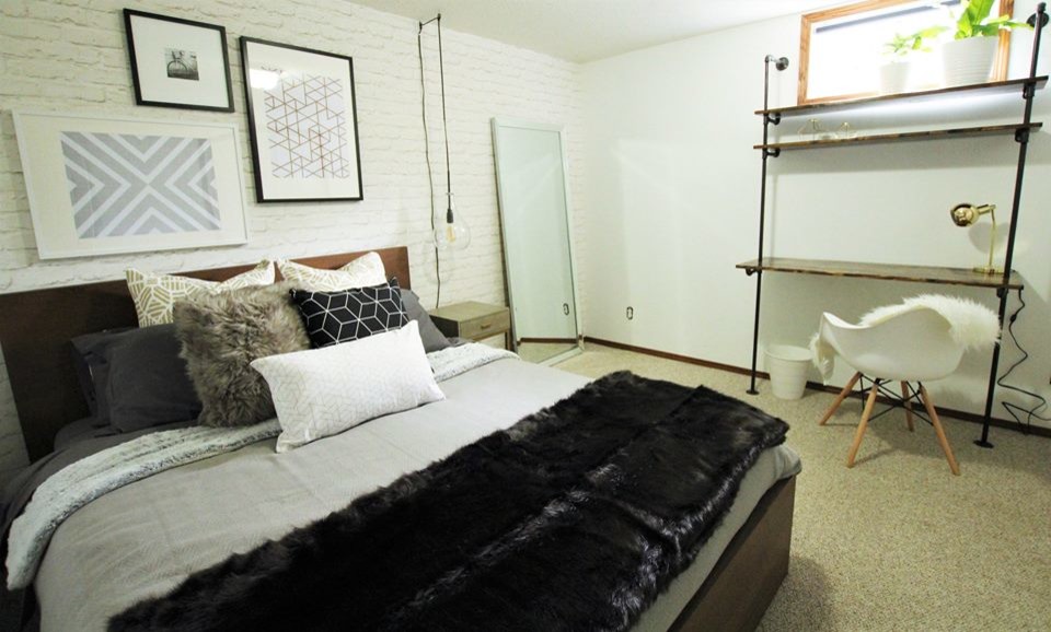 Imagen de dormitorio industrial de tamaño medio con paredes blancas, moqueta y suelo beige