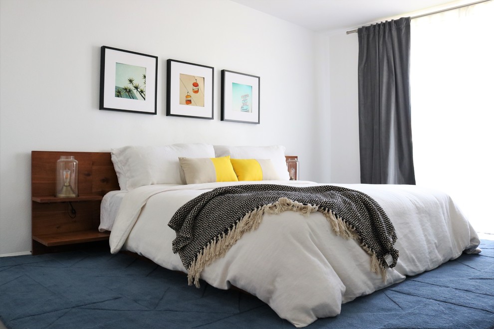 Imagen de dormitorio principal retro de tamaño medio con paredes blancas, moqueta y suelo azul