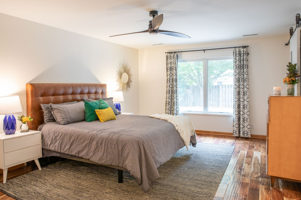 Inspiration for a mid-sized mid-century modern master medium tone wood floor and brown floor bedroom remodel in Indianapolis with white walls
