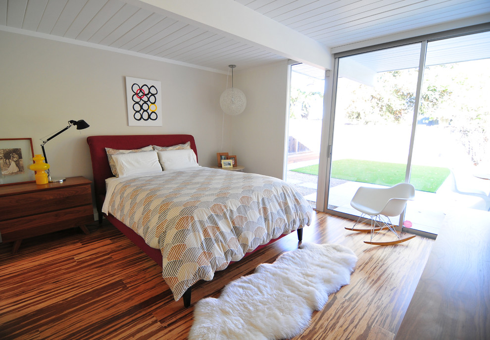 Diseño de dormitorio retro con paredes beige y suelo de bambú