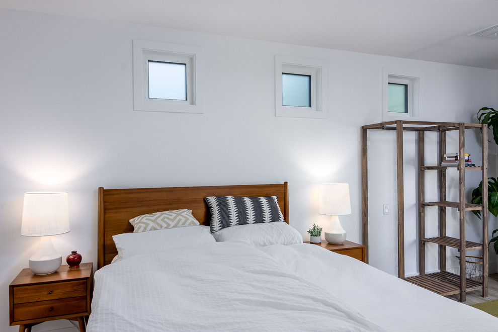 Ejemplo de habitación de invitados blanca y blanca y madera vintage extra grande sin chimenea con paredes blancas, suelo de madera clara y suelo marrón