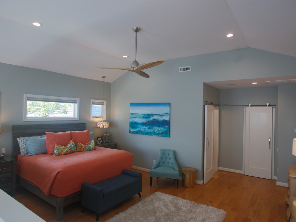 Large beach style master medium tone wood floor and brown floor bedroom photo in Other with gray walls