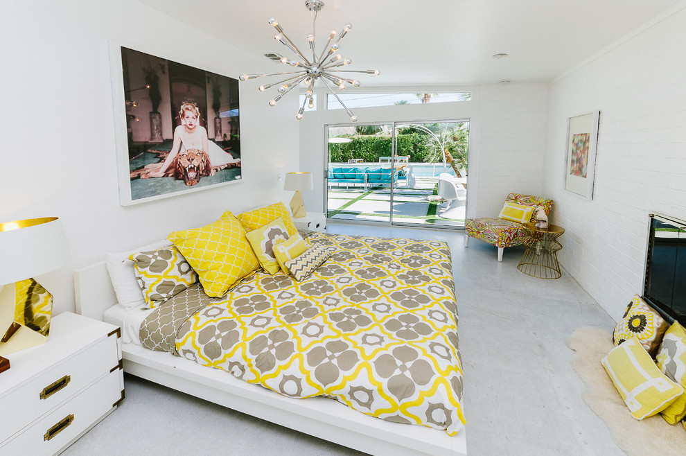 ロサンゼルスにある中くらいなモダンスタイルのおしゃれな客用寝室 (白い壁、コンクリートの床、標準型暖炉、レンガの暖炉まわり、白い床) のレイアウト