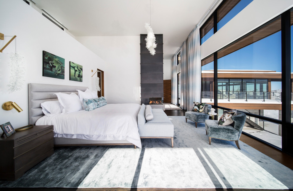Modernes Hauptschlafzimmer mit weißer Wandfarbe, dunklem Holzboden, Eckkamin und braunem Boden in Salt Lake City