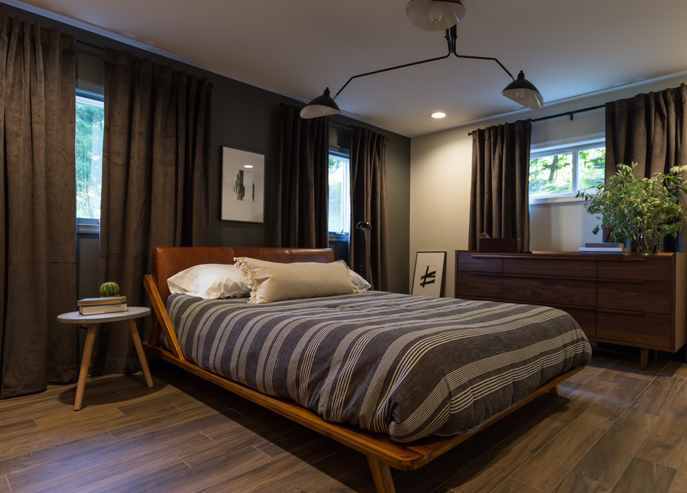 Modelo de dormitorio retro con paredes grises, suelo de madera en tonos medios y suelo marrón
