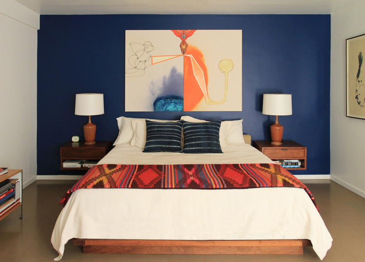 Ejemplo de dormitorio principal retro de tamaño medio con paredes azules y suelo de cemento
