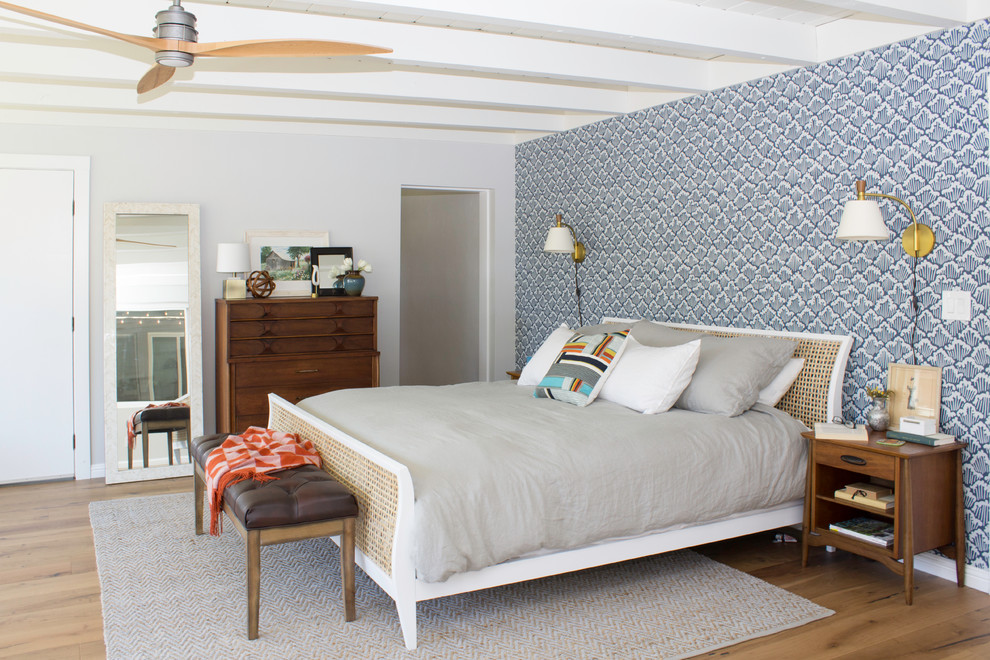 Imagen de dormitorio principal vintage grande sin chimenea con paredes azules y suelo de madera en tonos medios