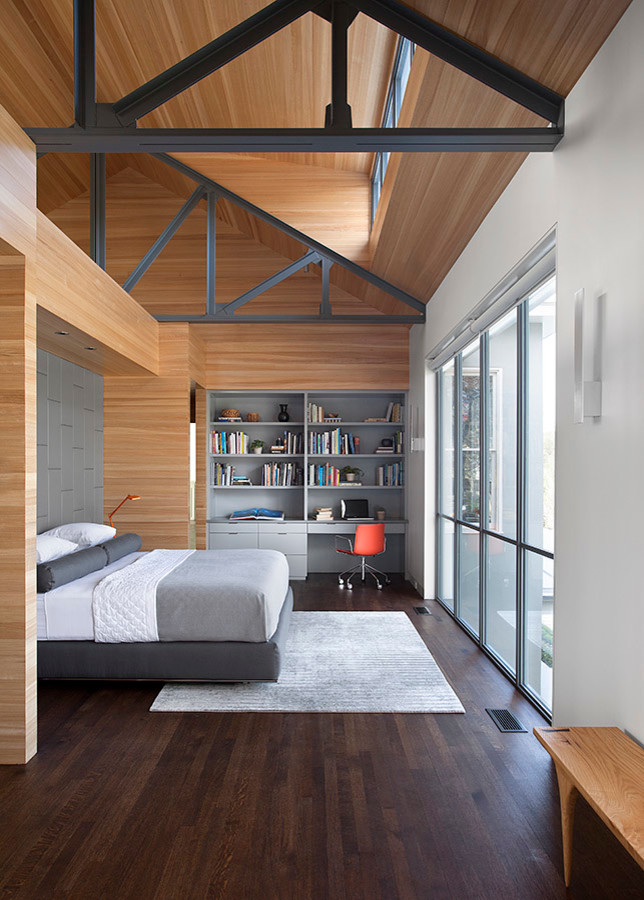 This is an example of a midcentury master bedroom in Austin with white walls and dark hardwood flooring.