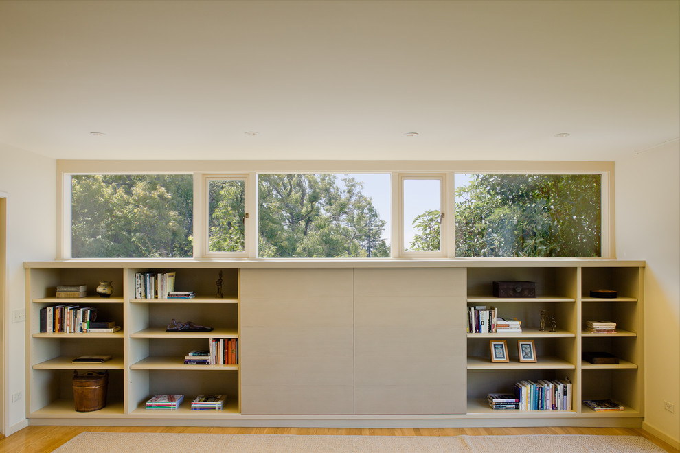 Ejemplo de dormitorio principal minimalista grande con paredes beige y suelo de madera en tonos medios
