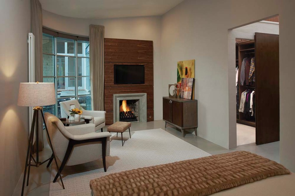 Design ideas for a medium sized midcentury master bedroom in Detroit with beige walls, concrete flooring, a standard fireplace, grey floors and a stone fireplace surround.