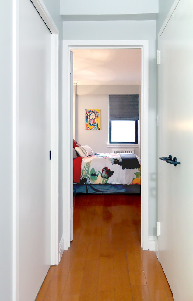 Foto di una piccola camera matrimoniale moderna con pareti grigie, pavimento in legno massello medio e pavimento marrone