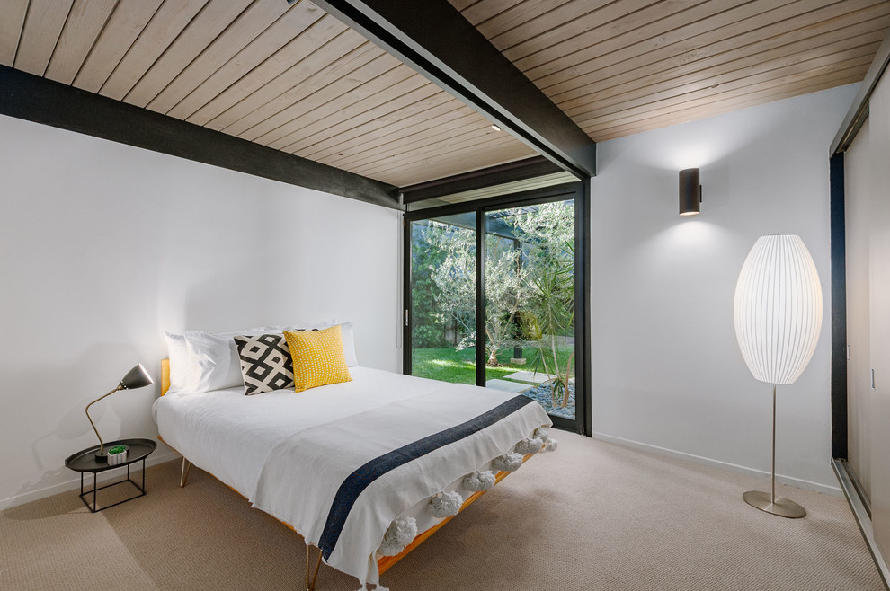 ロサンゼルスにある中くらいなミッドセンチュリースタイルのおしゃれな客用寝室 (白い壁、カーペット敷き、ベージュの床) のインテリア