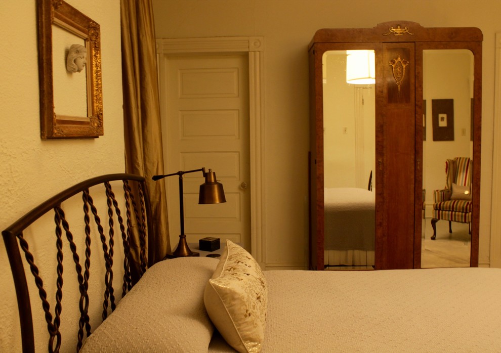На фото: хозяйская спальня среднего размера в стиле фьюжн с желтыми стенами и деревянным полом без камина с