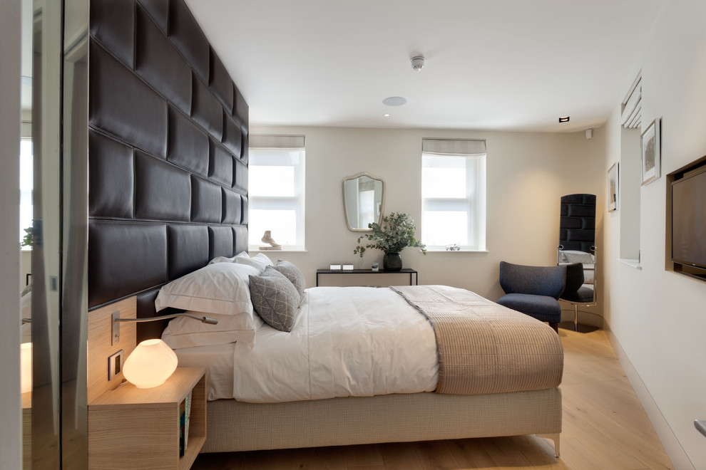 Example of a trendy light wood floor bedroom design in London
