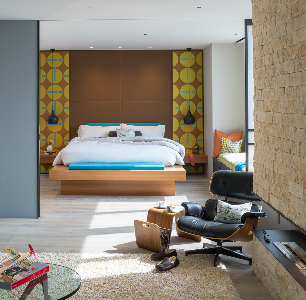 Стильный дизайн: хозяйская спальня в стиле ретро с коричневыми стенами, фасадом камина из камня и угловым камином - последний тренд
