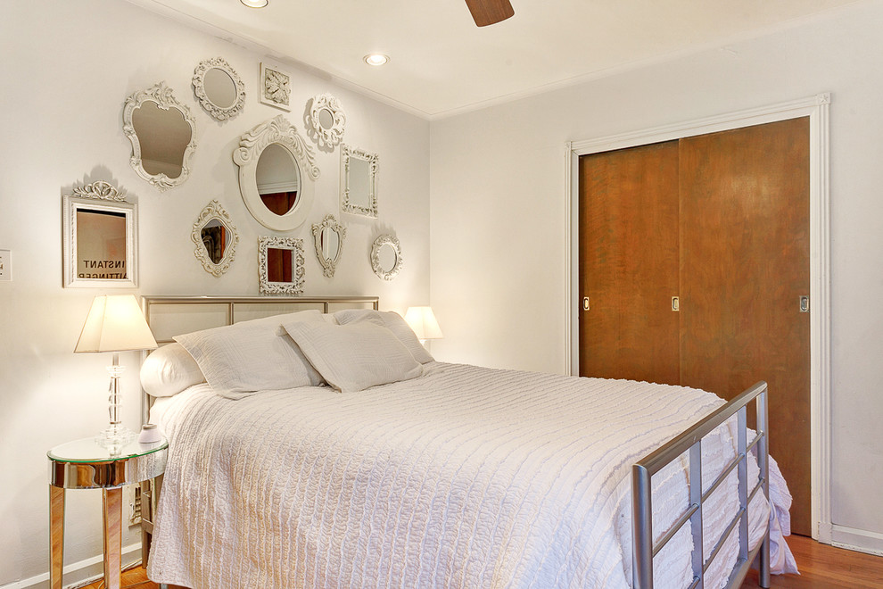 Cette photo montre une chambre rétro avec un mur blanc et un sol en bois brun.
