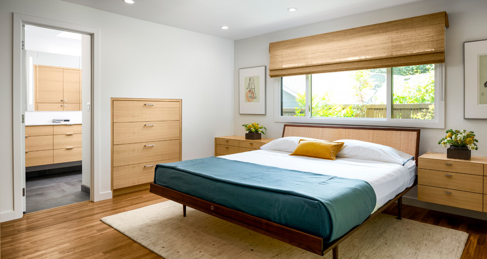 Diseño de dormitorio principal vintage grande sin chimenea con paredes blancas, suelo de madera clara y suelo marrón