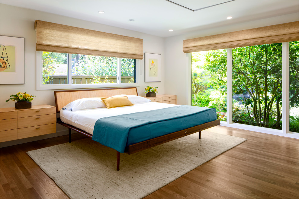 Ejemplo de dormitorio principal vintage grande sin chimenea con paredes blancas, suelo de madera clara y suelo marrón