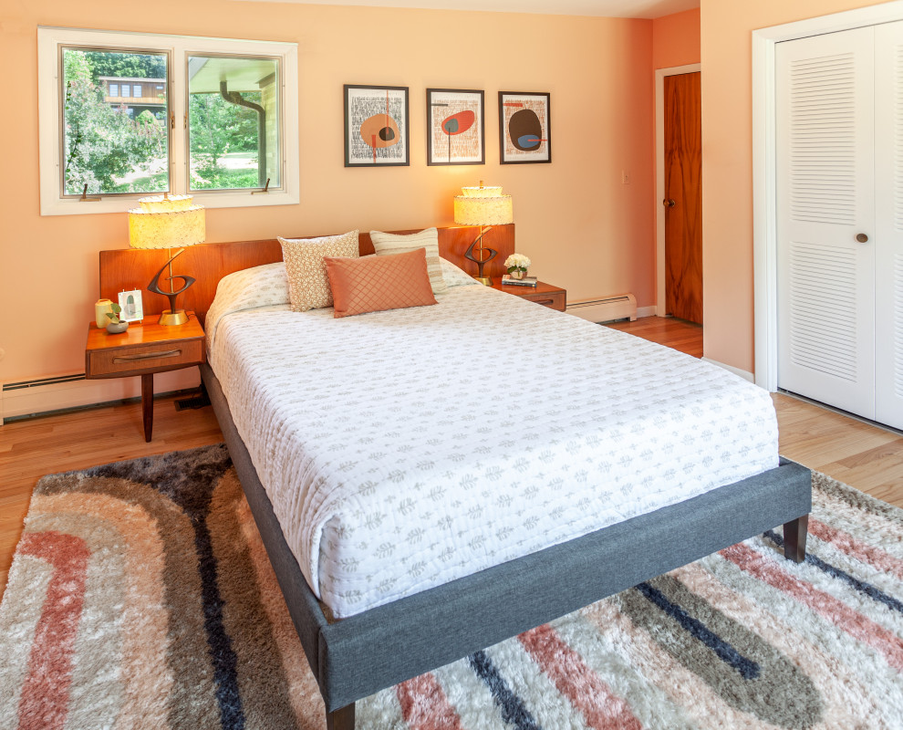 デトロイトにある中くらいなミッドセンチュリースタイルのおしゃれな主寝室 (ピンクの壁、無垢フローリング、茶色い床) のレイアウト