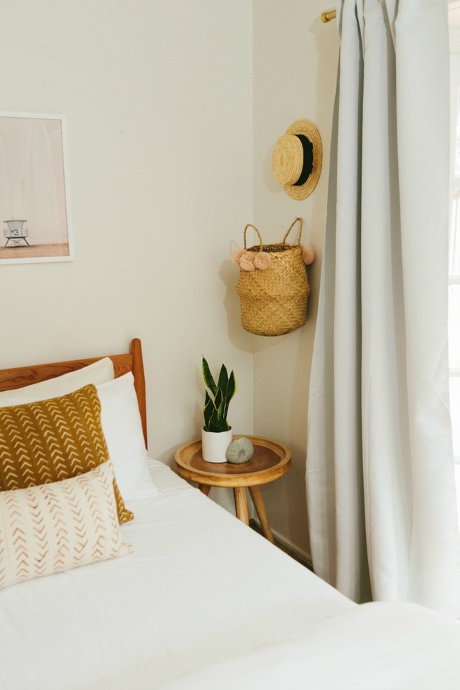 Foto di una piccola camera degli ospiti minimalista con pareti bianche, pavimento in laminato e pavimento marrone