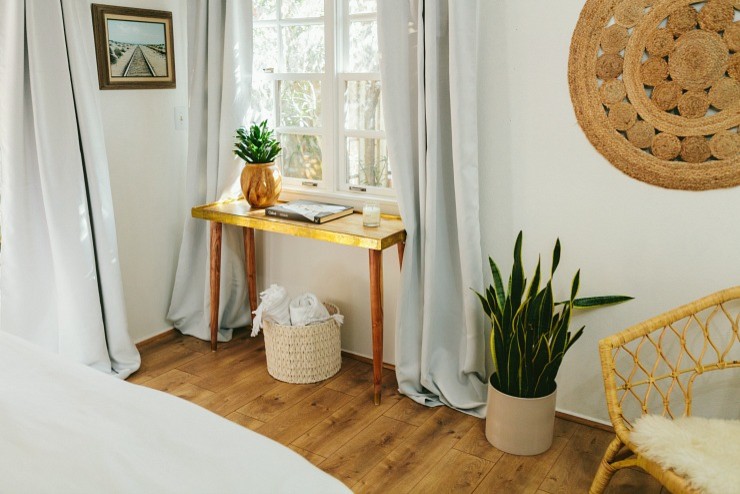Kleines Mid-Century Gästezimmer mit weißer Wandfarbe, Laminat und braunem Boden in San Diego