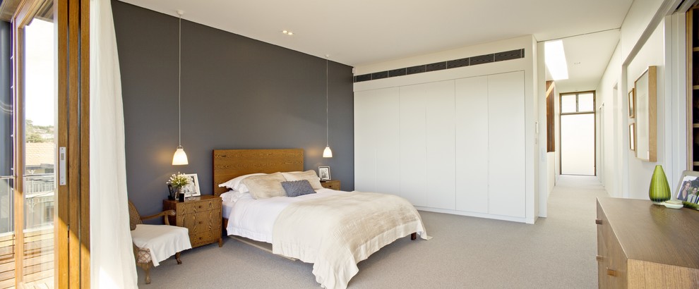 シドニーにあるコンテンポラリースタイルのおしゃれな主寝室 (グレーの壁、カーペット敷き)