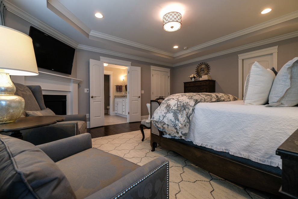 Источник вдохновения для домашнего уюта: хозяйская спальня в стиле неоклассика (современная классика) с серыми стенами, темным паркетным полом, угловым камином, фасадом камина из дерева и коричневым полом