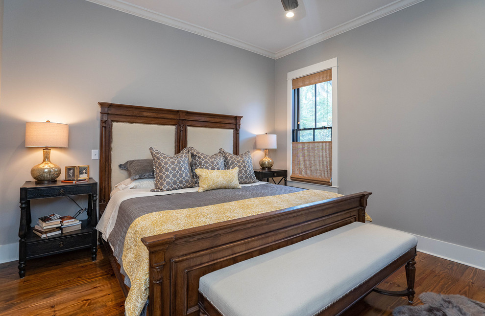 Foto på ett lantligt sovrum, med grå väggar, mörkt trägolv och brunt golv