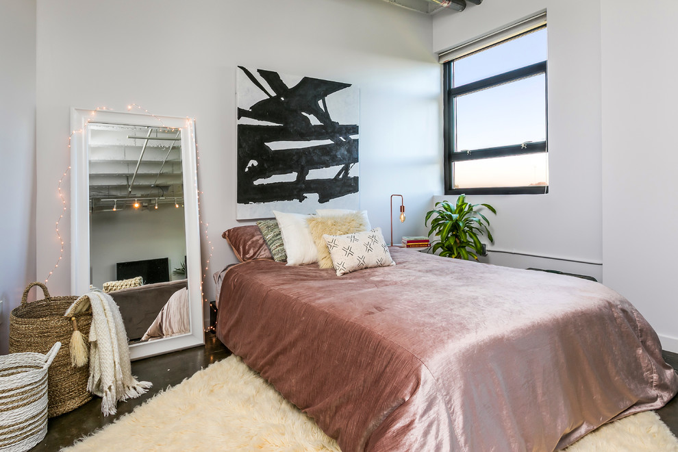 Imagen de dormitorio bohemio de tamaño medio sin chimenea con paredes blancas y suelo de cemento