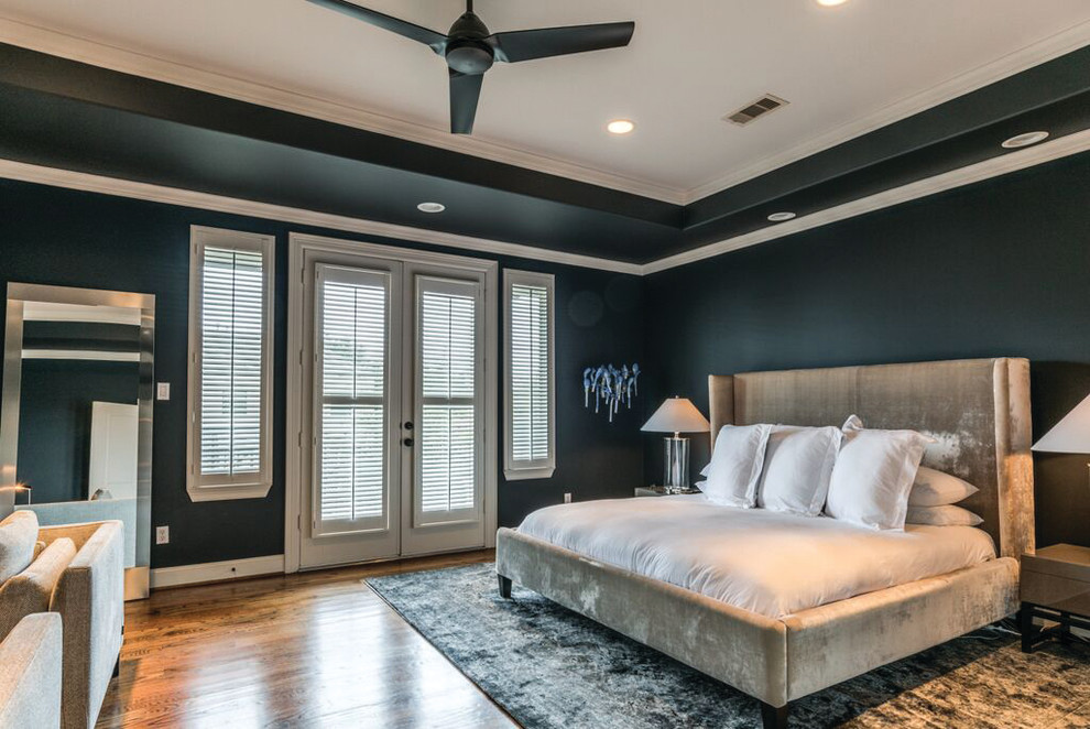 Diseño de dormitorio principal clásico renovado grande sin chimenea con paredes negras, suelo de madera en tonos medios y suelo marrón