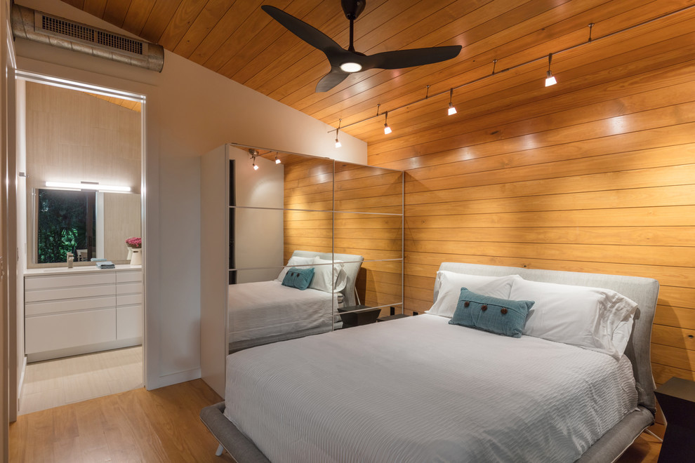 Example of a small urban master medium tone wood floor, multicolored floor, wood ceiling and wood wall bedroom design in Other with multicolored walls and no fireplace
