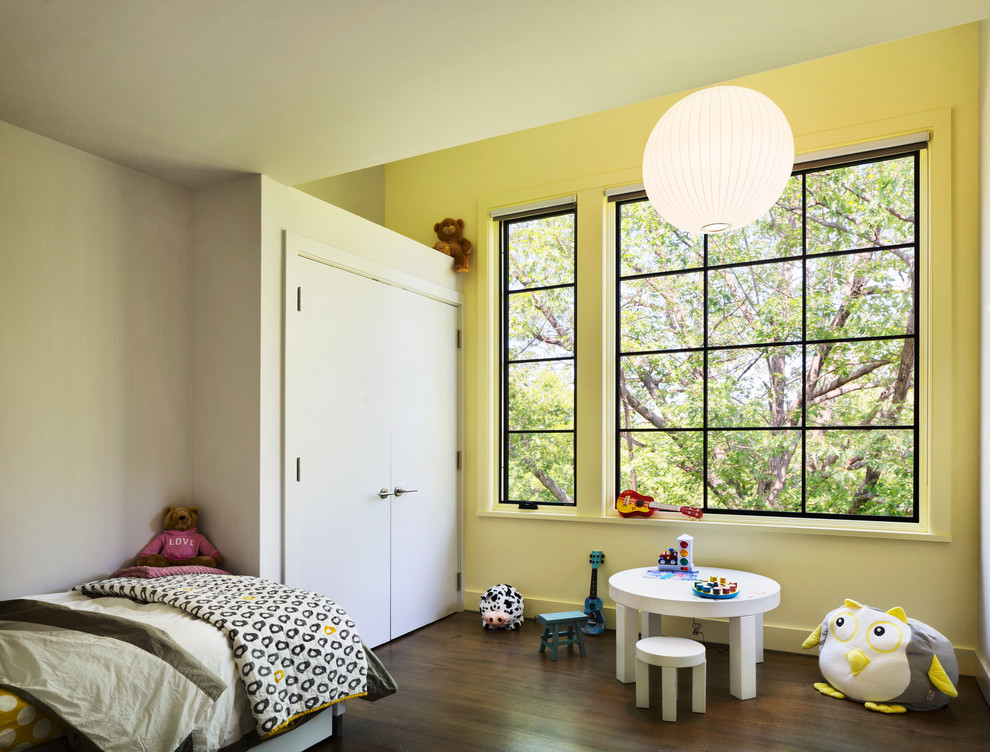 Exemple d'une petite chambre d'amis tendance avec un mur jaune, un sol en bois brun et aucune cheminée.