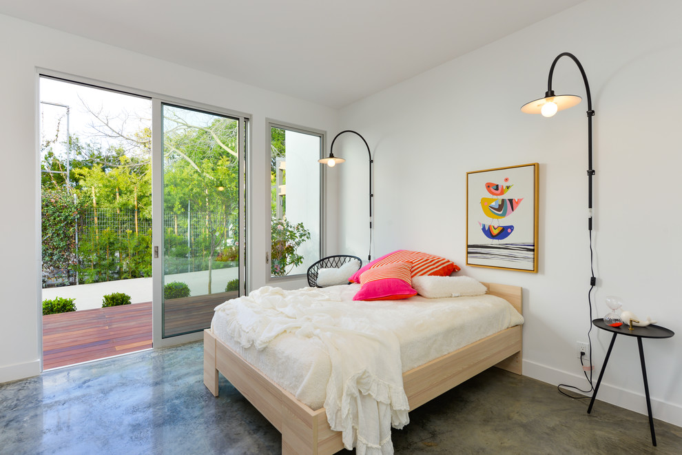 Large contemporary guest bedroom in Los Angeles with white walls, concrete flooring, no fireplace and grey floors.