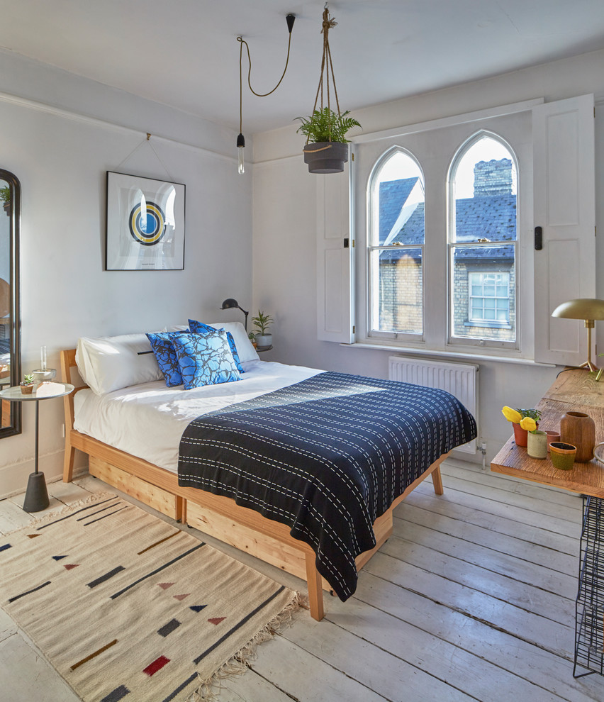 Mid-sized danish painted wood floor and white floor bedroom photo in Essex with gray walls